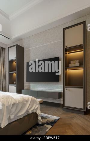 Élégant centre de divertissement de chambre avec une télévision murale et des étagères encastrées lumineuses. Un mélange harmonieux d'éléments de design modernes et classiques Banque D'Images