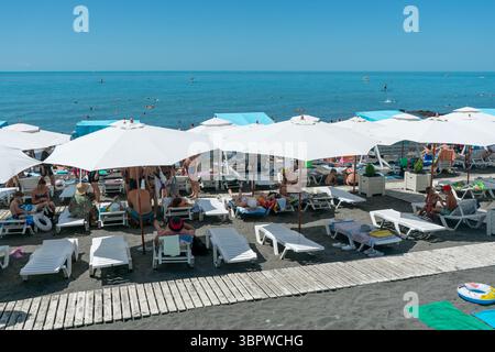 Sotchi, Russie - 05 juillet 2022 : plage de la ville au bord de la mer avec chaises longues et parasols. Banque D'Images