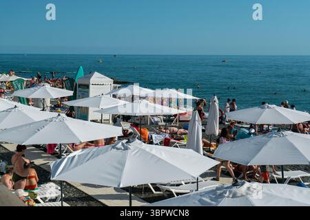 Sotchi, Russie - 05 juillet 2022 : plage de la ville au bord de la mer avec chaises longues et parasols. Banque D'Images