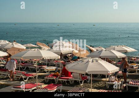 Sotchi, Russie - 05 juillet 2022 : plage de la ville au bord de la mer avec chaises longues et parasols. Banque D'Images