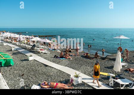 Sotchi, Russie - 05 juillet 2022 : plage de la ville au bord de la mer avec chaises longues et parasols. Banque D'Images