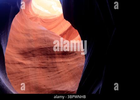 Une lumière brillante illumine les formations tourbillonnantes de grès d'Antelope Canyon, créant un contraste visuel époustouflant au cœur de page Banque D'Images