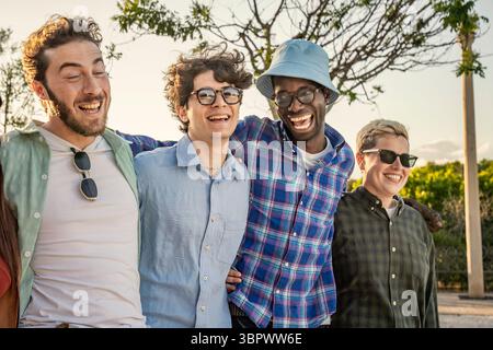 Un portrait en gros plan authentique et franc de quatre jeunes hommes heureux et divers riant de tout cœur ensemble à l'extérieur, partageant un moment d'amitié authentique Banque D'Images