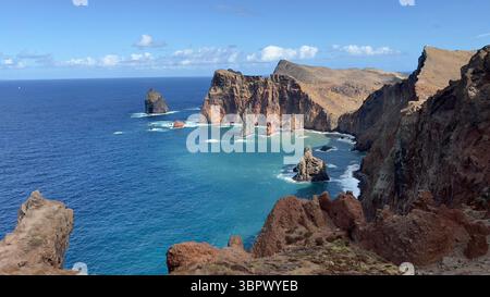 Vue imprenable sur les falaises spectaculaires rencontrant l'océan bleu vibrant par une journée lumineuse., Madère, Portugal Banque D'Images