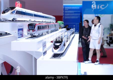 Un modèle du train CR450 EMU (ci-dessous), développé par l'Académie chinoise des sciences ferroviaires, attire les visiteurs. Beijing, Chine.9th juillet 2025. La 17e exposition internationale des technologies et équipements ferroviaires modernes de Chine, qui s'est tenue parallèlement au 12e Congrès mondial sur le train à grande vitesse, a attiré de nombreux visiteurs au China National Convention Center à Pékin, capitale de la Chine, le 9 juillet 2025. Crédit : Zhang Xiangyi/China News Service/Alamy Live News Banque D'Images