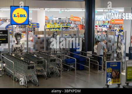 Poznan, Pologne - 18 juin 2025 : vue intérieure d'un supermarché LIDL avec des acheteurs et des chariots soigneusement agencés, représentant l'épicerie moderne reta Banque D'Images