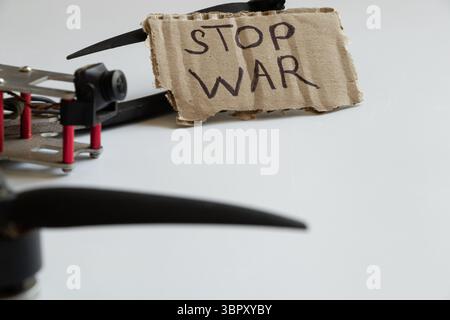 Drone de combat avec signe D'ARRÊT DE GUERRE, message anti-guerre sur fond d'un drone russe sur fond blanc, message Banque D'Images