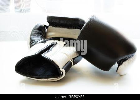 Gants de boxe noirs et blancs sur fond blanc, gants pour la boxe et l'entraînement Banque D'Images