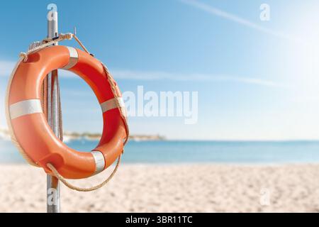 Cercle de bouées de sauvetage. Vue panoramique de bouée de sauvetage rouge et blanche sur le poteau sur la plage de bord de mer. Paysage de paysage de la rive de l'océan de mer le jour ensoleillé. Sauvetage en eau Banque D'Images