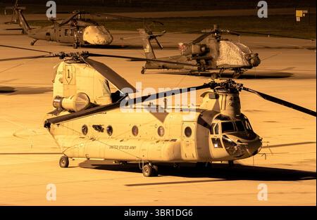 Les hélicoptères Boeing CH-47F Chinook, AH-64E Apache Guardian et Sikorsky UH-60M Blackhawk de l'armée AMÉRICAINE sur le tarmac lors d'un arrêt de nuit à l'aéroport d'Eindhoven Banque D'Images