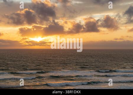 Coucher de soleil sur les vagues de l'océan Atlantique, vu de Perranporth, Cornouailles Banque D'Images