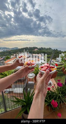 Petit déjeuner nourrissant et visuellement attrayant avec du yaourt, des baies et des graines tenus dans les mains des femmes contre un paysage serein. Bien-être et conscient Banque D'Images