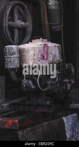 Vieux moteur diesel sur un chantier de construction, montrant la ténacité et l'usure de l'équipement lourd. Banque D'Images