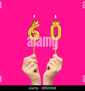 Mains tenant des bougies en forme de chiffres - numéro d'anniversaire 60 Banque D'Images