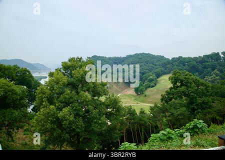 Gongju, Corée du Sud - 13 juin 2025 : une vue luxuriante sur les collines couvertes d'arbres et une rivière sinueuse vue depuis les terrains élevés de la forteresse de Gongsanseong Banque D'Images