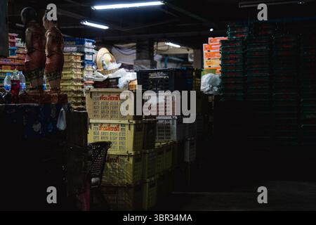 Bangkok, Thaïlande. 11 juillet 2025. Des piles de boîtes en plastique sont utilisées pour le transport des fruits au marché. Chaque matin à Bangkok, des moines bouddhistes marchent dans les rues pour recevoir des aumônes, des offrandes de nourriture et de fleurs de la communauté laïque. À proximité, au marché aux fleurs de Yodpiman, des fleurs sont préparées et vendues pour être utilisées dans ces rituels quotidiens enracinés dans la tradition bouddhiste Theravada. (Photo de Ploy Phutpheng/SOPA images/Sipa USA) crédit : Sipa USA/Alamy Live News Banque D'Images