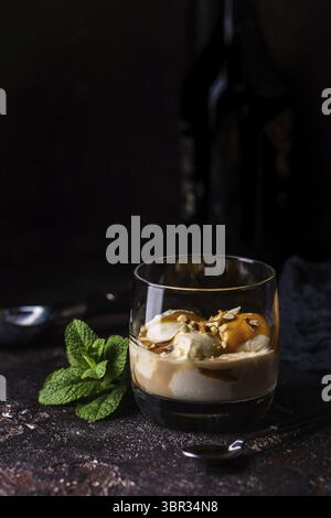 Crème glacée avec garniture de caramel et liqueur de crème irlandaise dans un verre sur fond foncé Banque D'Images