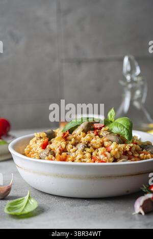 Bulgur avec des cœurs de poulet et des légumes. Délicieux plat sain sur un fond gris. Bulgur pilaf Banque D'Images