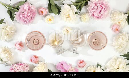 Composition florale avec différentes variétés de vin rosé, cocktail alcoolisé d'été pour une fête et fleurs de pivoine sur un fond clair, le concept o Banque D'Images