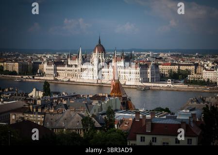 Vue du Parlement hongrois projette une silhouette majestueuse contre le Danube, les toits et le ciel, Budapest, Hongrie centrale, Hongrie. Banque D'Images