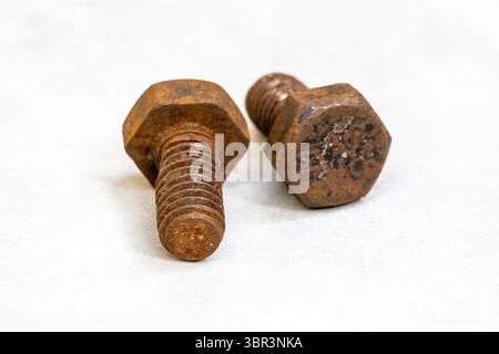 Deux vieux boulons en fer rouillés sans écrous, isolés sur un fond blanc. Métal très vieux, texturé, corrodé. Banque D'Images