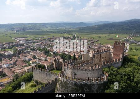Vue aérienne de l'ancien Castello Scaligero debout fièrement au milieu des toits de tuiles rouges de la ville et des collines verdoyantes environnantes, Castello Scaligero, Vene Banque D'Images
