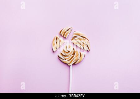 Sucette caramel sur fond rose. Pose à plat. Concept minimal Banque D'Images