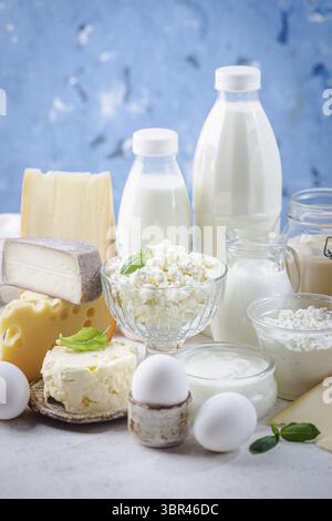 Produits laitiers frais, lait, fromage cottage, œufs, yaourt, crème sure et beurre sur fond bleu Banque D'Images