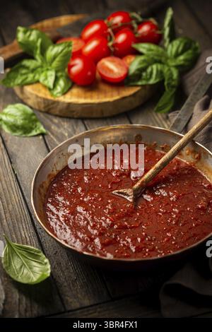 Sauce tomate italienne maison classique avec basilic pour pâtes et pizza dans la poêle sur fond en bois Banque D'Images