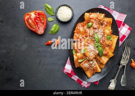 Paccheri Pâtes avec sauce tomate et basilic dans une assiette, vue d'en haut Banque D'Images