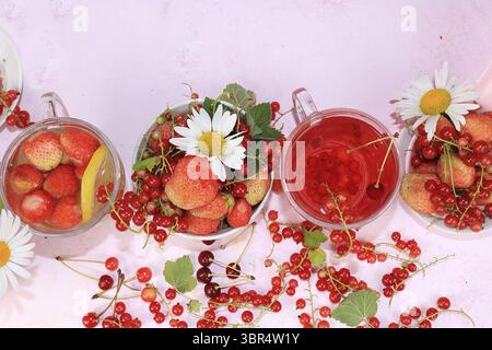 Boissons estivales, jus de fraise et de groseille avec baies. Délicieuse limonade molle de groseilles et de fraises sur un fond rose, vue de dessus, copie Banque D'Images