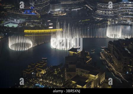 Dubaï, Émirats arabes Unis - 16 juin 2025 : vue aérienne de l'éblouissant spectacle de la fontaine de Dubaï, ses jets lumineux dansant sur l'eau sombre, reflétant les lumières scintillantes de la ville. Banque D'Images