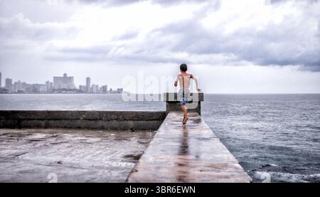 29 juin 2011, la Havane, la Havane, Cuba : un garçon court le long du mur du Malecon de la Havane pendant une averse estivale. (Crédit image : © Carlos Escalona/ZUMA Wire) Banque D'Images