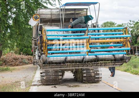 Récolteuse de riz moderne sur la route rurale en Thaïlande Banque D'Images