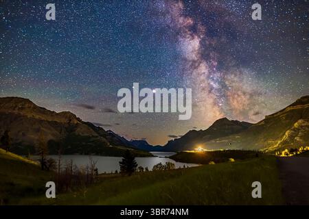 14 juillet 2020, Alberta, Canada : la zone centrale galactique de la voie lactée au-dessus du parc national des Lacs-Waterton, Alberta avec l'appariement de planètes géantes à partir de l'été 2020. Jupiter est l'objet lumineux au centre, avec Saturne dimmer à gauche (est) de Jupiter. En 2020, les deux planètes étaient proches l'une de l'autre dans le ciel d'été. Le Sagittaire est à droite. L'hôtel Prince of Wales est la source lumineuse. C'était du 13 au 14 juillet 2020... il s'agit d'une pile de 10 expositions pour le sol, moyenne combinée pour lisser le bruit dans le premier plan sombre, avec le ciel d'une exposition, le tout sans suivi pendant 25 secondes à f/2 Wit Banque D'Images