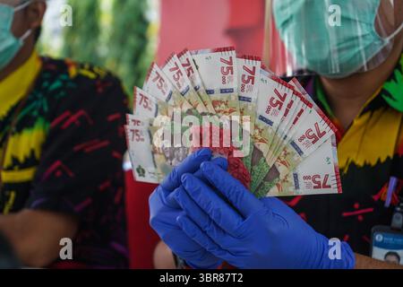 18 août 2020, Makassar, Sulawesi du Sud, Indonésie : un agent de banque tenait un nouveau billet de 75 000 roupies. À compter d'aujourd'hui, Bank Indonesia a émis de nouveaux billets d'une valeur de 75 000 roupies pour commémorer le 75e anniversaire de l'Indonésie. Les nouveaux billets ont été imprimés sur 75 millions de feuilles de papier. (Crédit image : © Herwin Bahar/ZUMA Wire) Banque D'Images