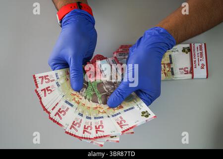 18 août 2020, Makassar, Sulawesi du Sud, Indonésie : un agent de banque tenait un nouveau billet de 75 000 roupies. À compter d'aujourd'hui, Bank Indonesia a émis de nouveaux billets d'une valeur de 75 000 roupies pour commémorer le 75e anniversaire de l'Indonésie. Les nouveaux billets ont été imprimés sur 75 millions de feuilles de papier. (Crédit image : © Herwin Bahar/ZUMA Wire) Banque D'Images