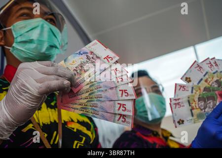 18 août 2020, Makassar, Sulawesi du Sud, Indonésie : un agent de banque tenait un nouveau billet de 75 000 roupies. À compter d'aujourd'hui, Bank Indonesia a émis de nouveaux billets d'une valeur de 75 000 roupies pour commémorer le 75e anniversaire de l'Indonésie. Les nouveaux billets ont été imprimés sur 75 millions de feuilles de papier. (Crédit image : © Herwin Bahar/ZUMA Wire) Banque D'Images
