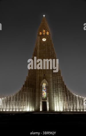 Vue sur l'église de Hallgrímskirkja se dresse contre le ciel nocturne sombre, sa façade illuminée est un phare dans la capitale islandaise, Reykjavík, Reykjavíku Banque D'Images