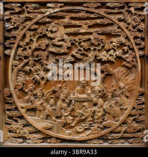 Une scène de sculpture en bas-relief asiatique détaillée avec des figures, probablement narratives dans la nature, disposées dans un paysage d'arbres et de nuages stylisés Banque D'Images