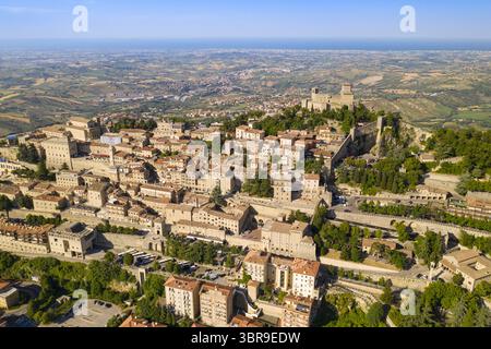 Vue aérienne d'anciens bâtiments en pierre se prélasser sous le soleil, avec la forteresse Guaita perchée au sommet, surplombant le paysage, Saint-Marin, Saint-Marin. Banque D'Images
