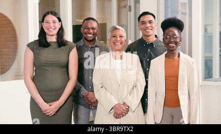 Équipe professionnelle diversifiée souriante dans un environnement de bureau lumineux, mettant en valeur le travail d'équipe et la collaboration Banque D'Images