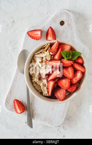 Bol d'avoine multigrain avec fraises fraîches, confiture de baies et noix. Porridge sain pour le petit déjeuner, vue panoramique Banque D'Images