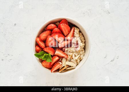 Bol d'avoine multigrain avec fraises fraîches, confiture de baies et noix. Porridge sain pour le petit déjeuner, vue panoramique Banque D'Images