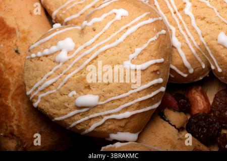 Petits gâteaux en forme de cœur fraîchement cuits recouverts d'un délicieux filet de glaçage. Banque D'Images