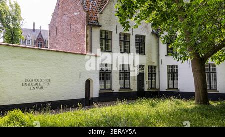 Bruges, Belgique - 4 juin 2025 : poème au mur blanc du Béguinage (Begijnhof) de l'une des maisons mitoyennes de Bruges en Flandre Belgique Banque D'Images