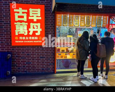 Shanghai, Chine, Teens Standing, From Behind, cuisine taïwanaise locale, Shop Front, Street, Night, Sign Outside Banque D'Images
