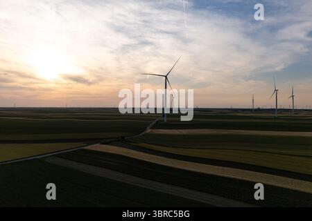Vue aérienne des éoliennes sur un champ agricole au coucher du soleil Banque D'Images