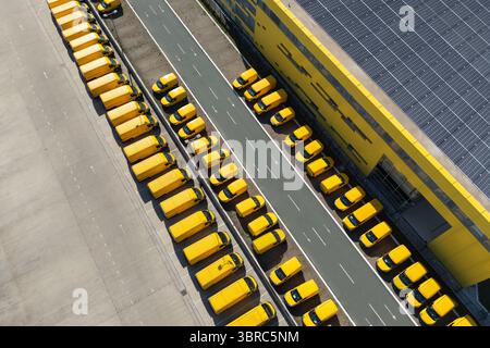 Moyeu de fourgonnettes de livraison avec panneau solaire sur un toit. Flotte de véhicules de poste jaune. Banque D'Images