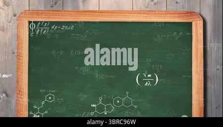 Tableau vert penché à ossature de bois dans l'étude montrant des formules chimiques et physiques sur le mur de planches Banque D'Images